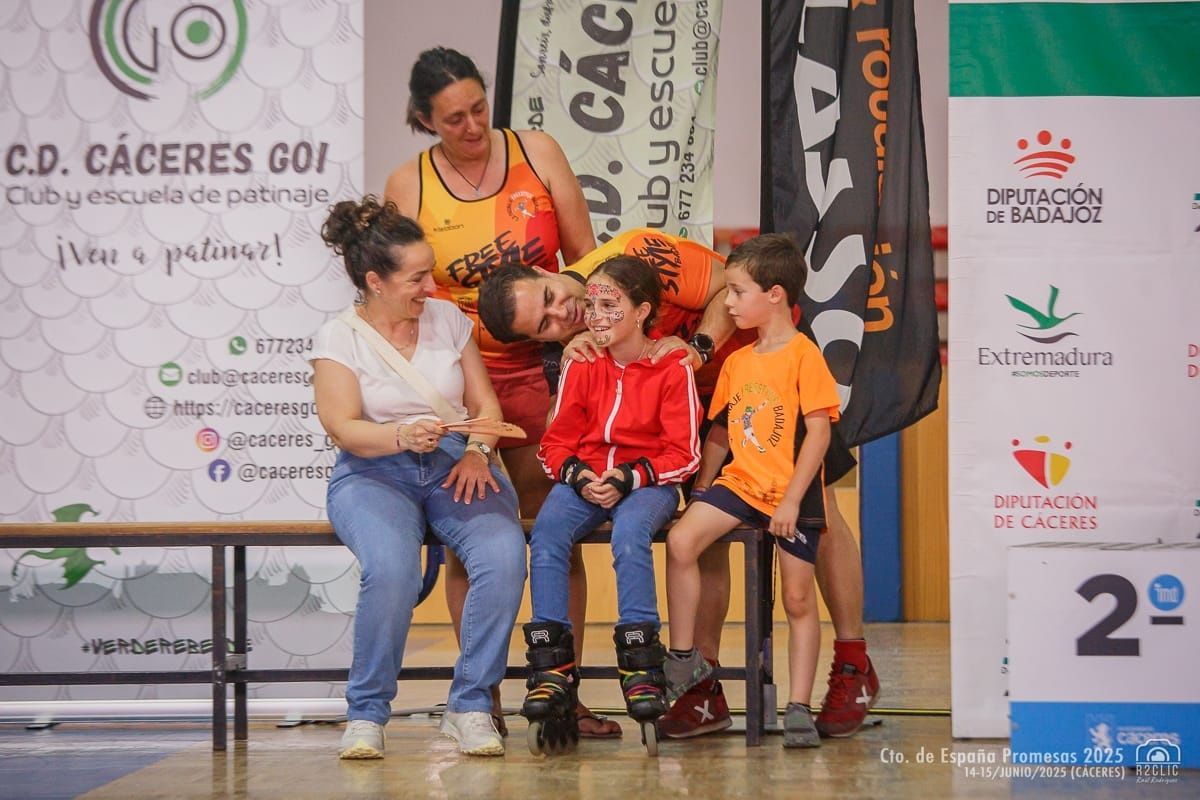 Grupo celebrando un premio de patinaje. Niños en patines, sonriendo con sus entrenadores en una pista cubierta.
