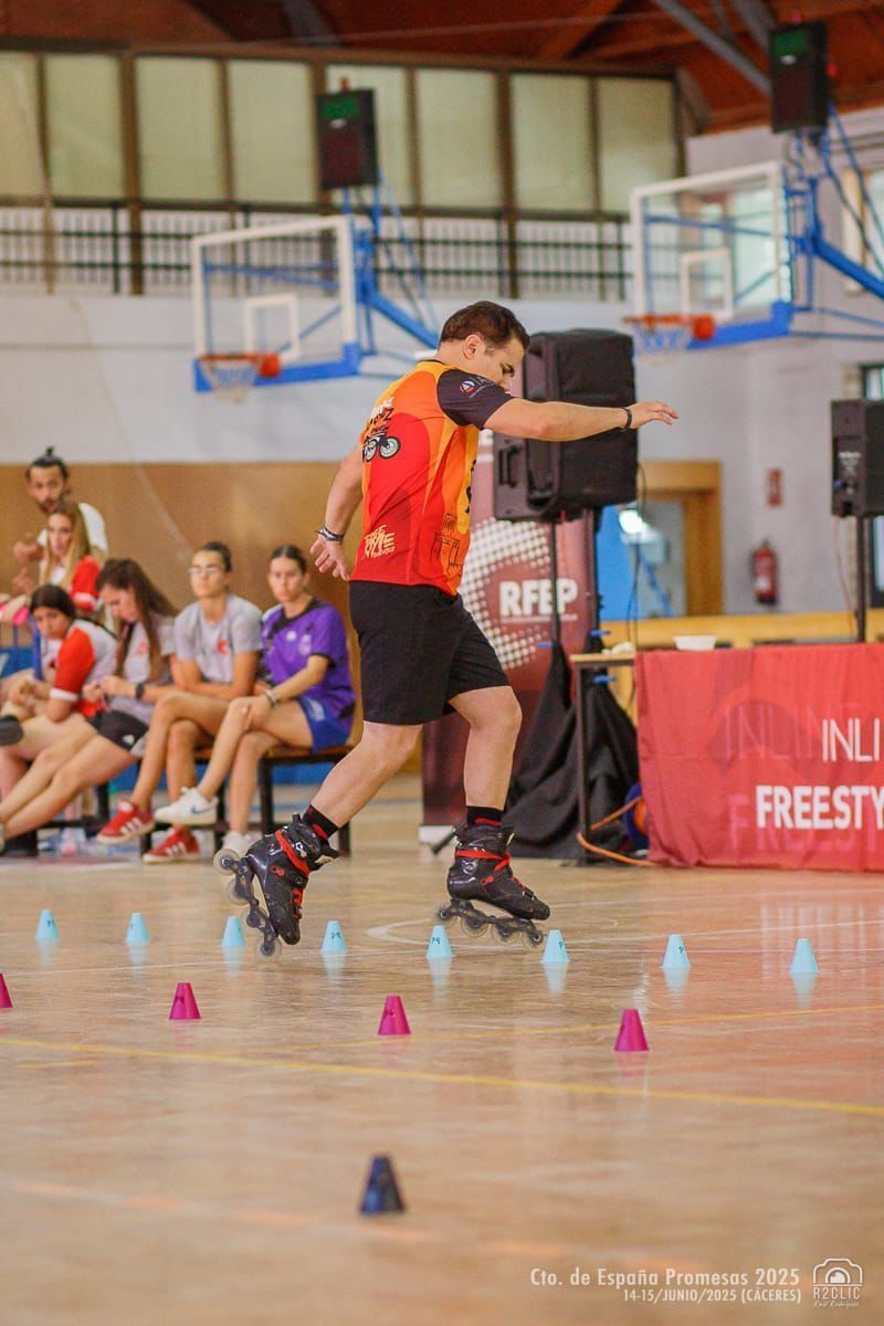 Hombre en patines navegando entre conos en una competición en interiores.
