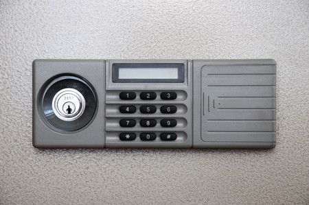 Serrure électronique grise à clavier avec lecteur d'empreintes digitales et petit écran.