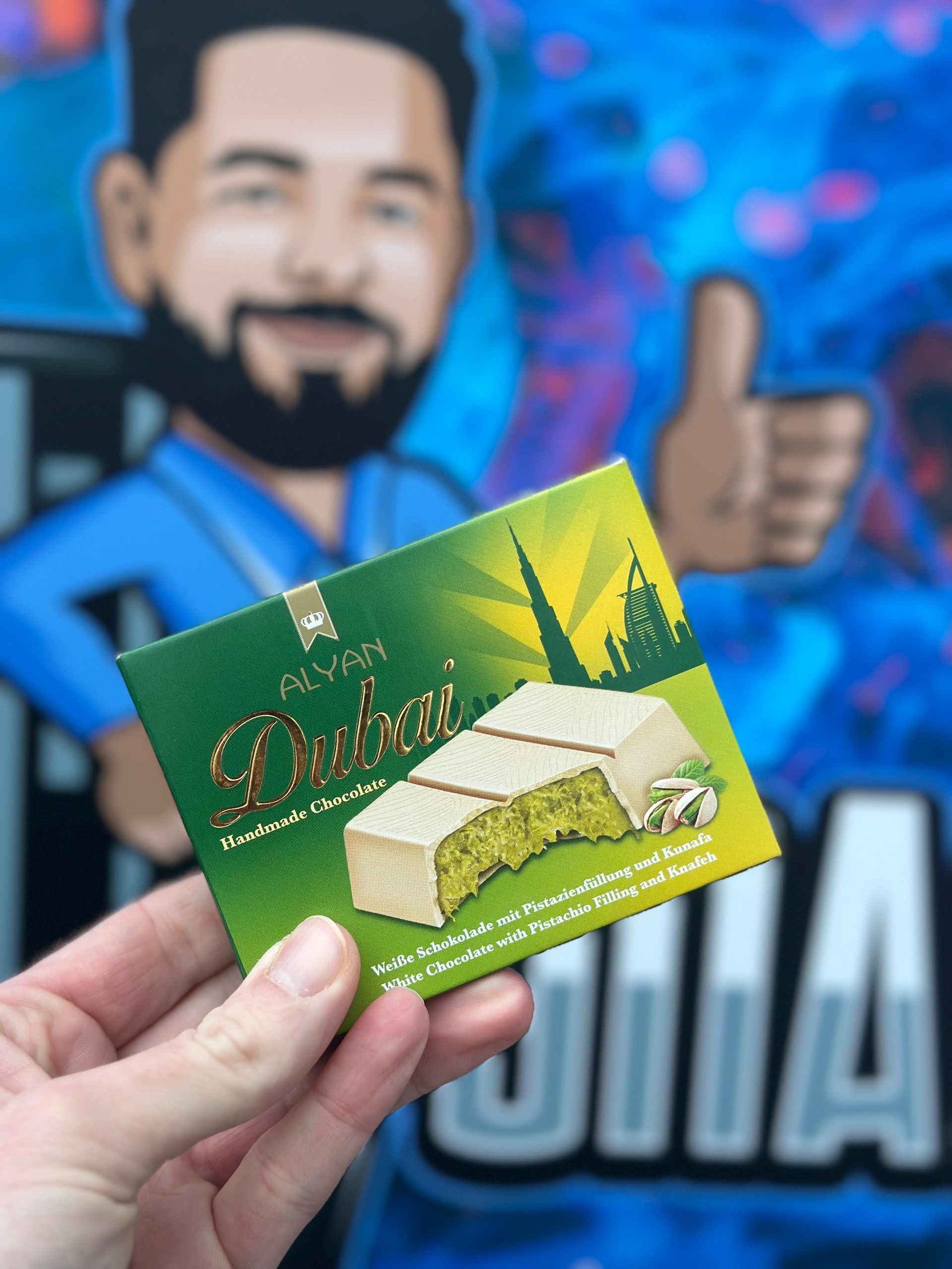 Ein Mann mit Bart hält ein Stück Schokolade