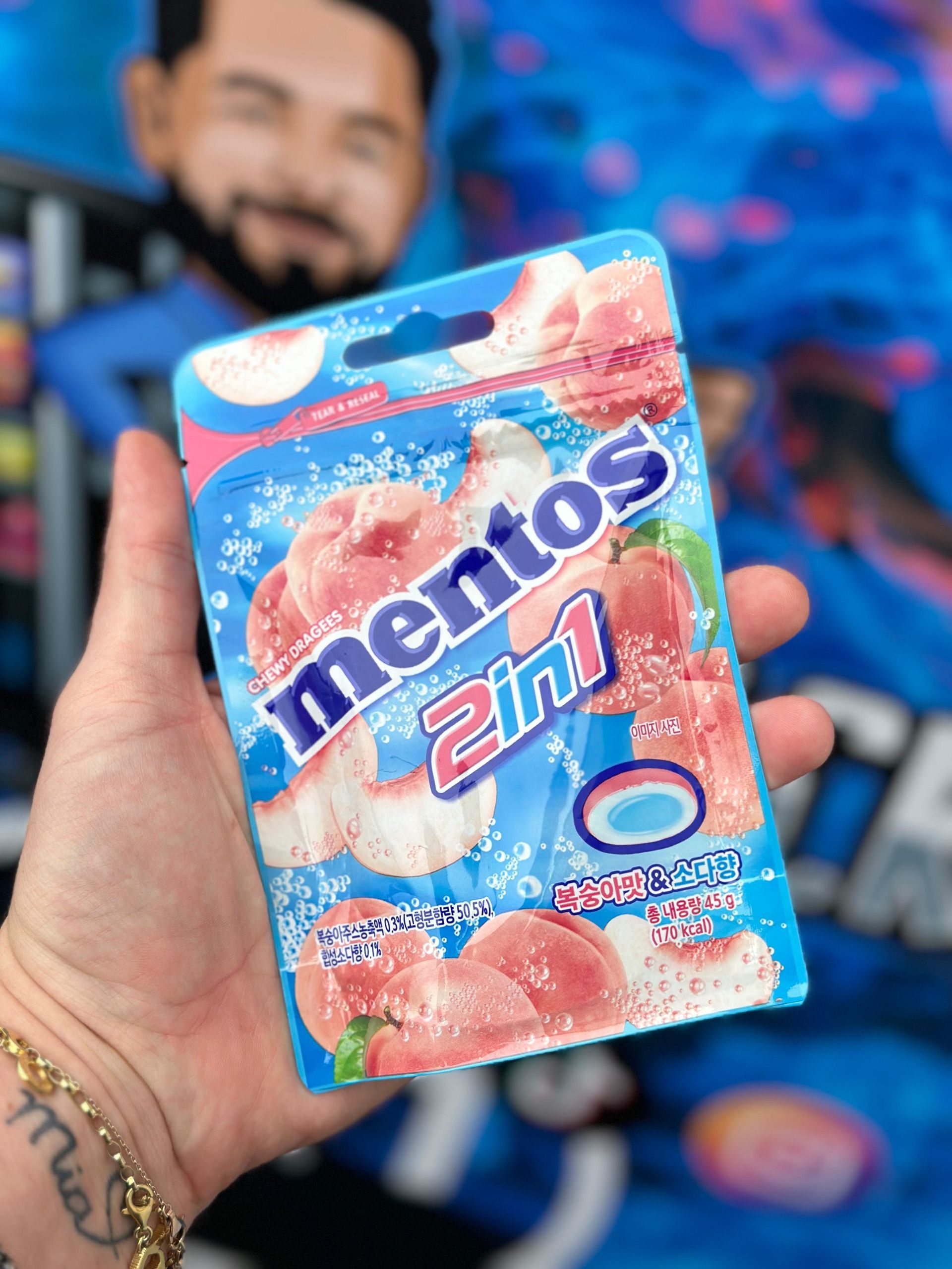 Eine Person hält eine Tüte Mentos 2 in 1