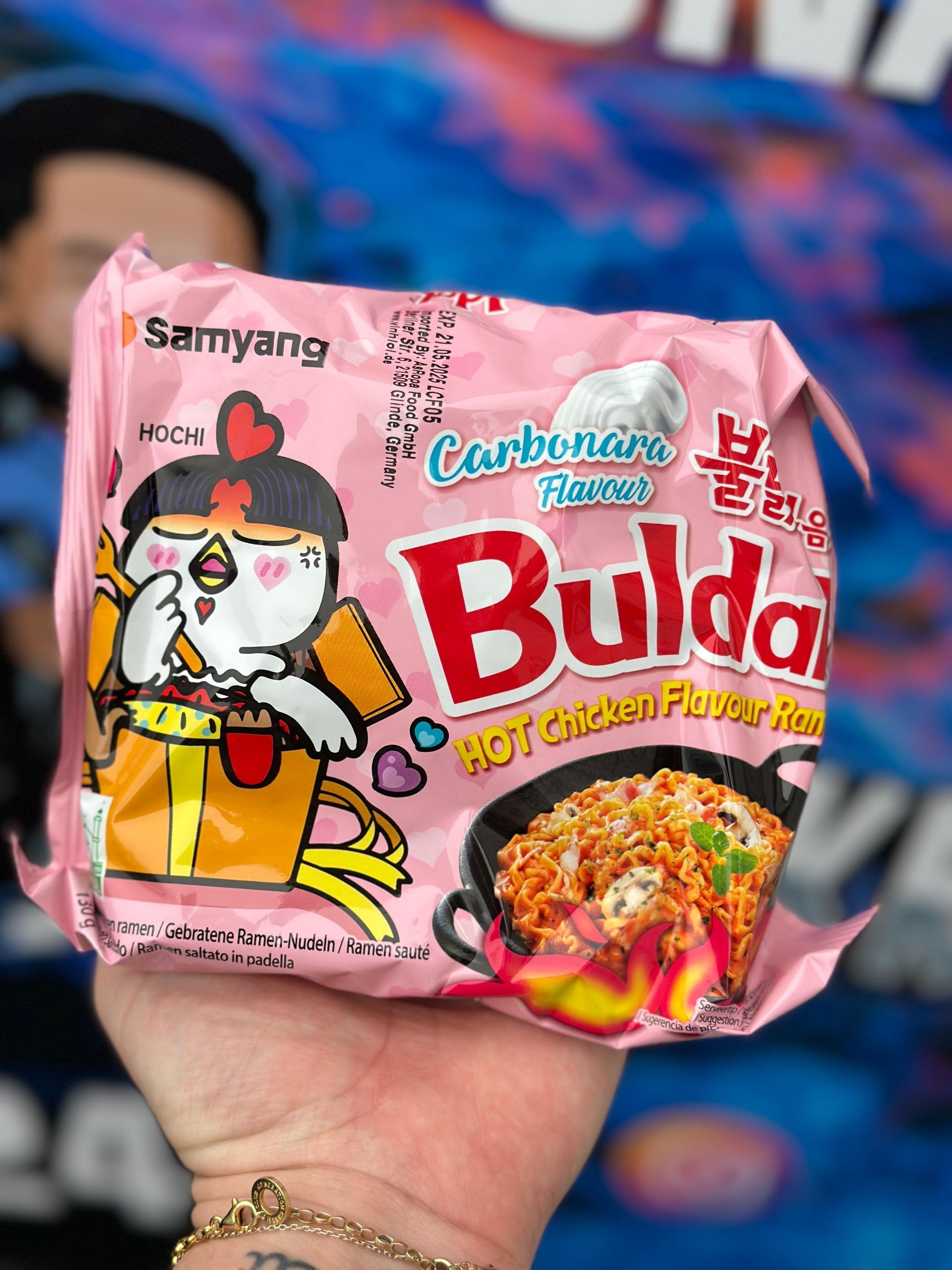 Eine Person hält eine Packung Buldak-Nudeln