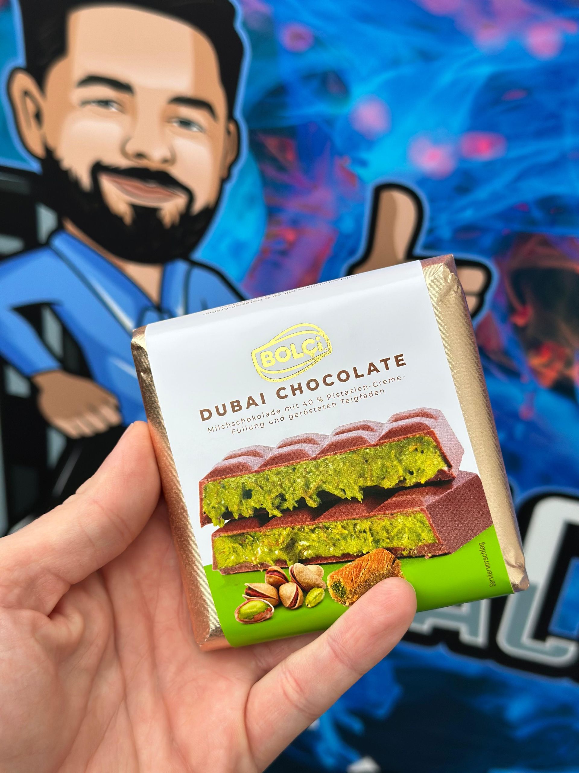 Eine Person hält eine Tafel Dubai-Schokolade mit Pistazien