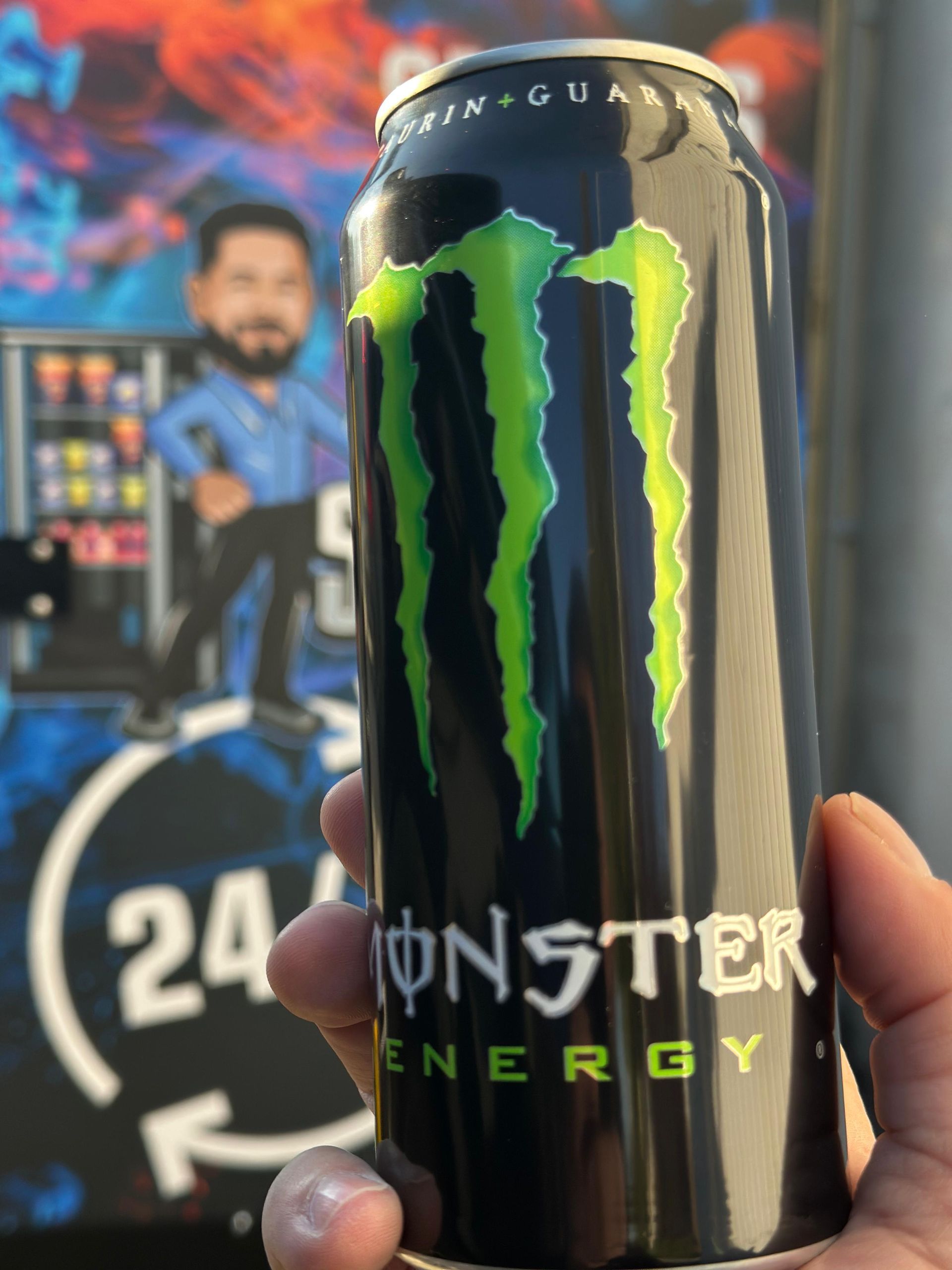 Eine Person hält eine Dose Monster-Energydrink