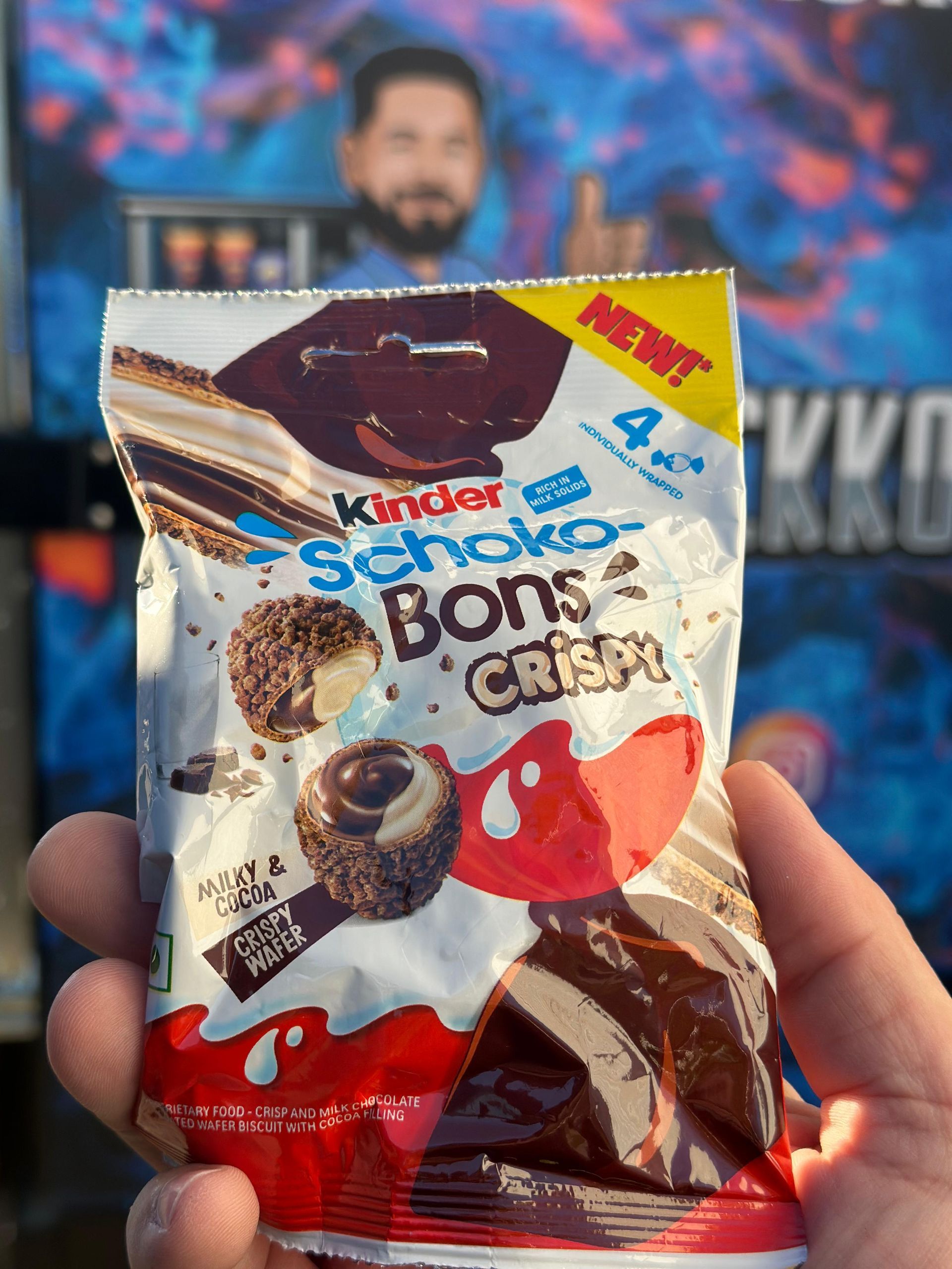 Eine Person hält eine Tüte Kinder Schoko Bons Crispy