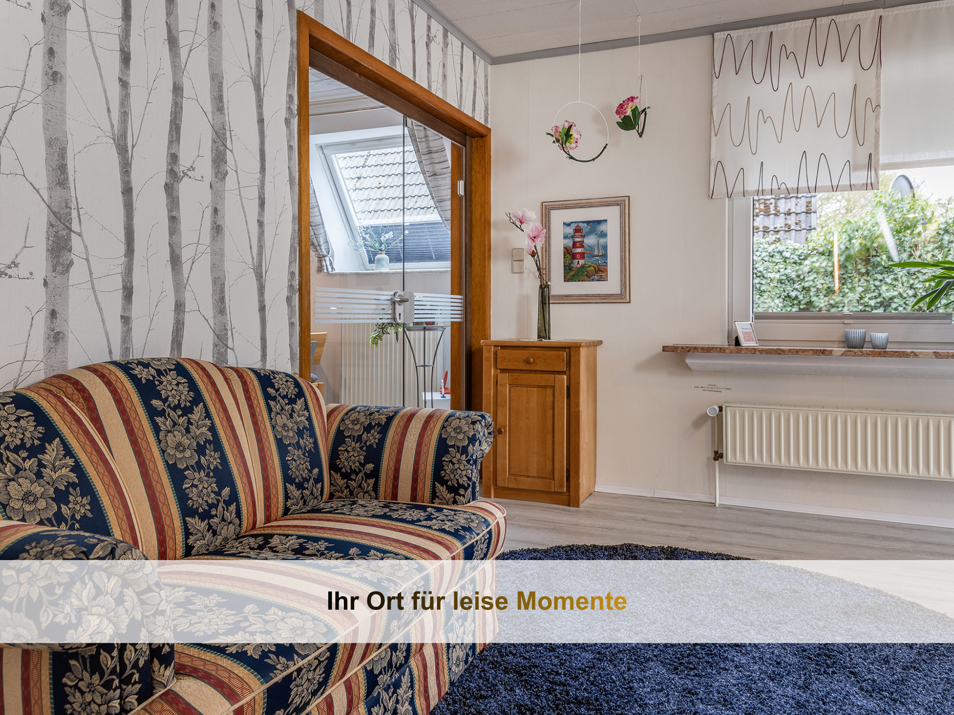 Wohnbereich der Ferienwohnung KUMM RIN mit Blick ins Grüne  und Friesensofa