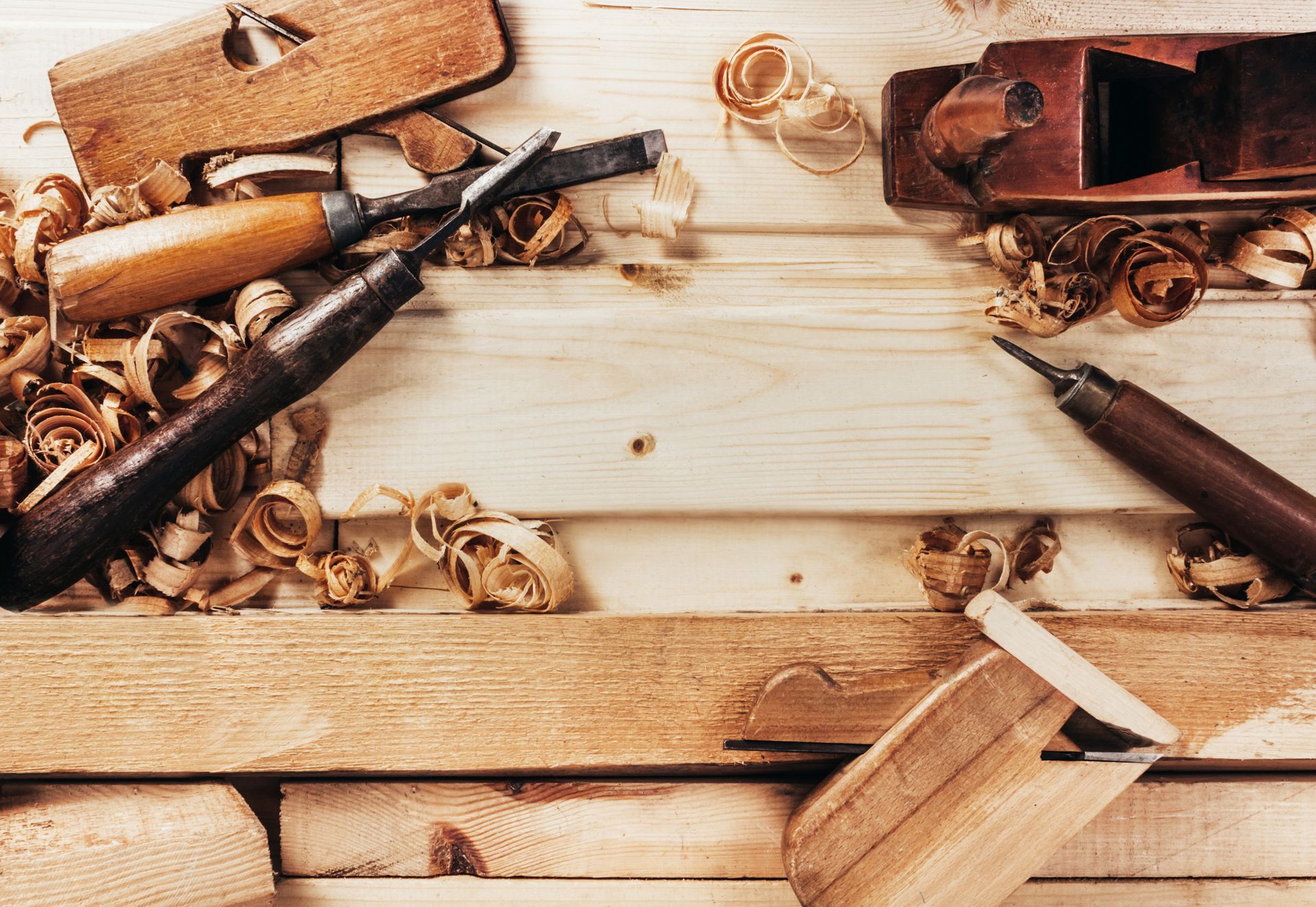 Herramientas para trabajar la madera con virutas de madera sobre una superficie de madera.
