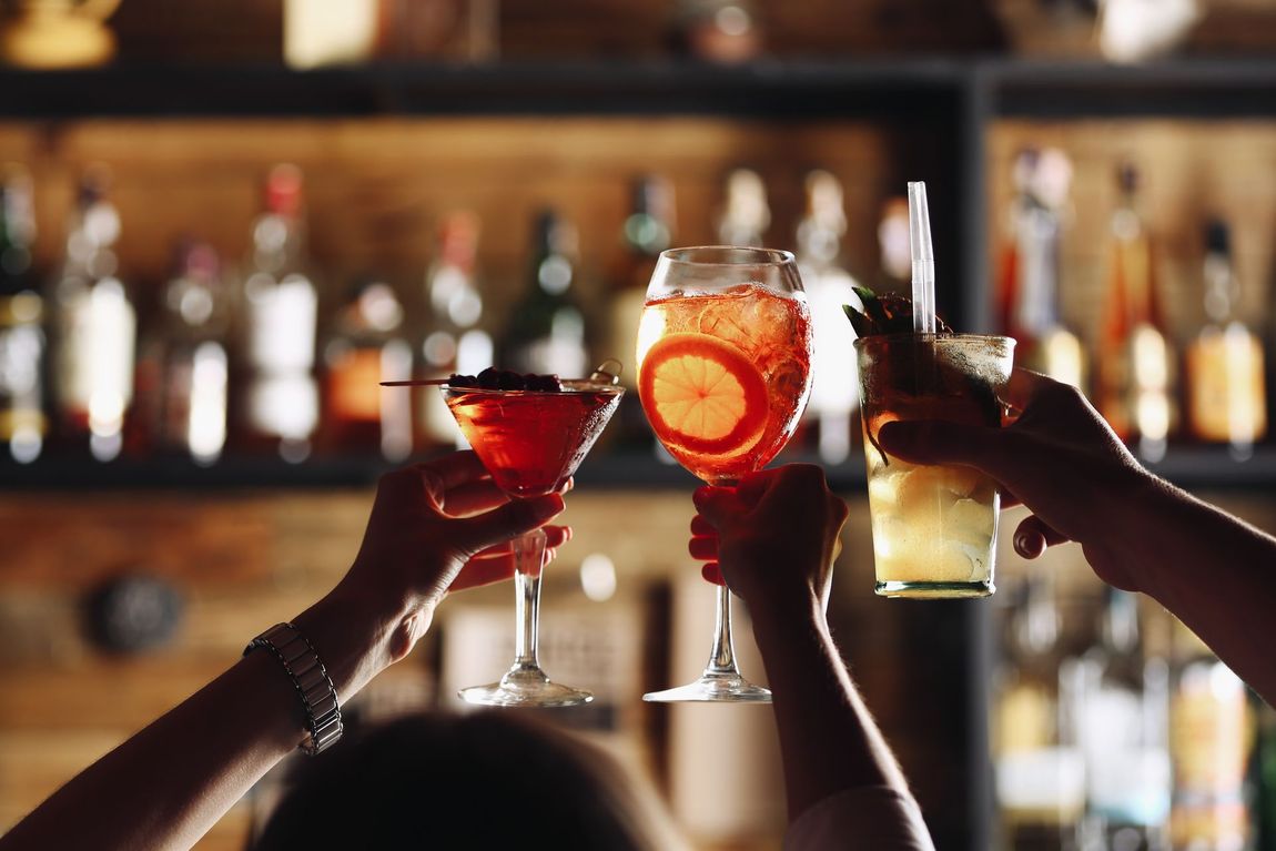 Gruppe stoßt mit Cocktails an