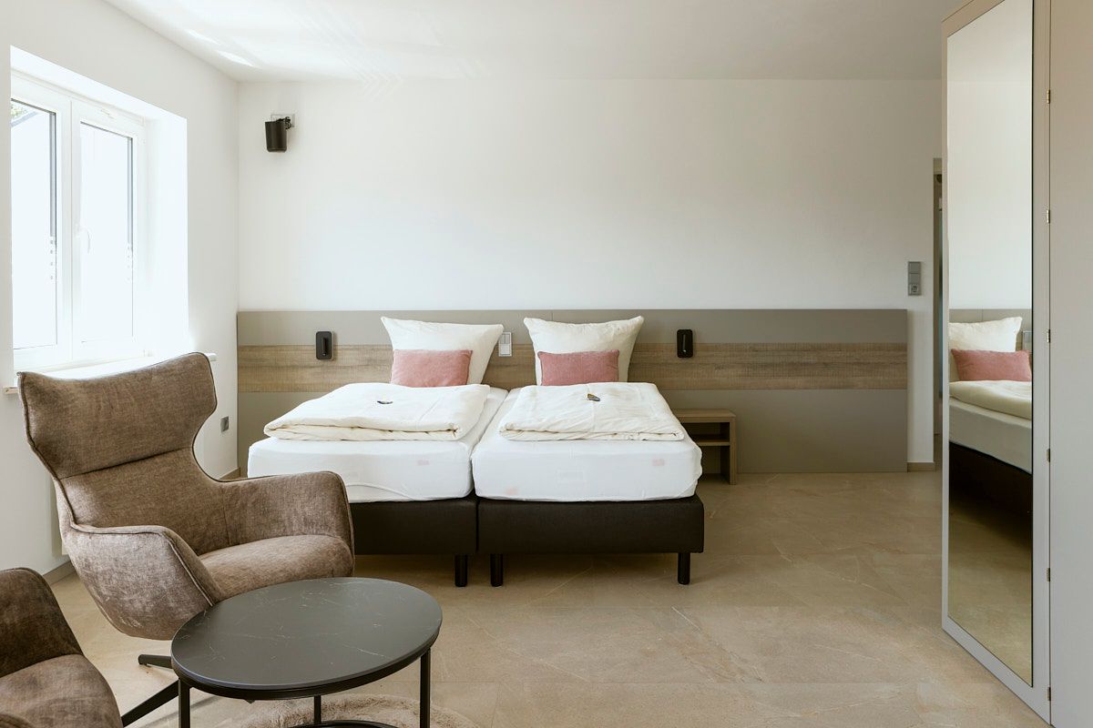 Hotelzimmer mit Doppelbett und Sessel