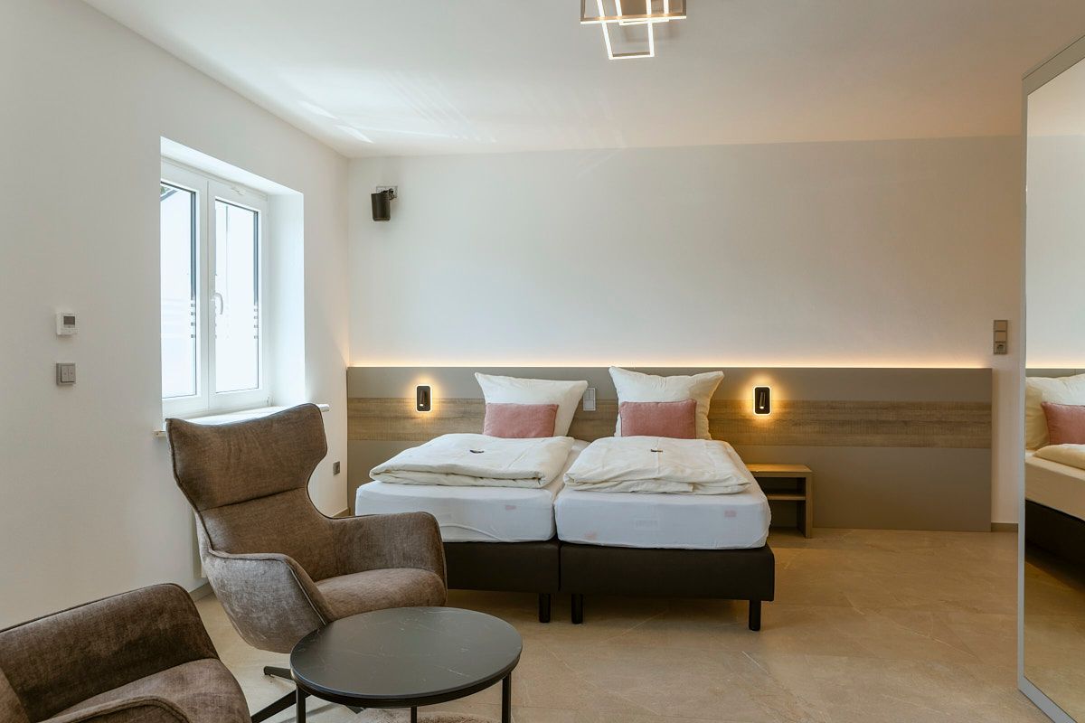 Hotelzimmer mit Doppelbett und Sessel