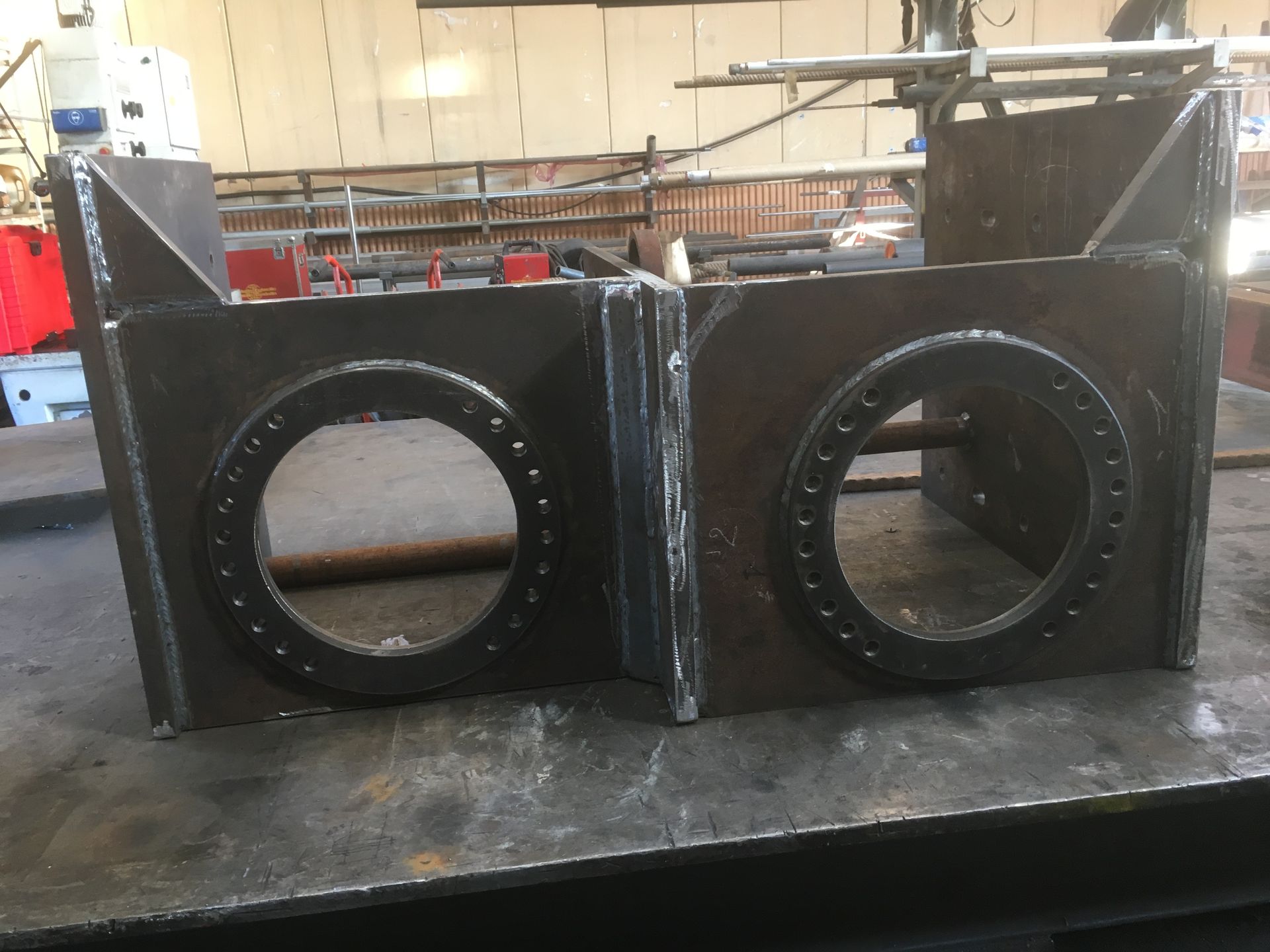 Deux boîtes en acier soudé avec de grands trous circulaires.