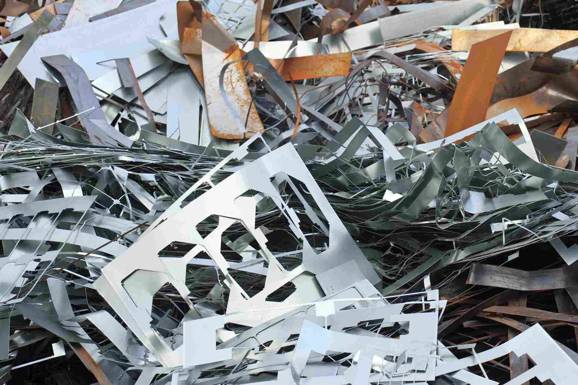 Un montón de chatarra con diversos recortes industriales, láminas de metal y fragmentos oxidados.