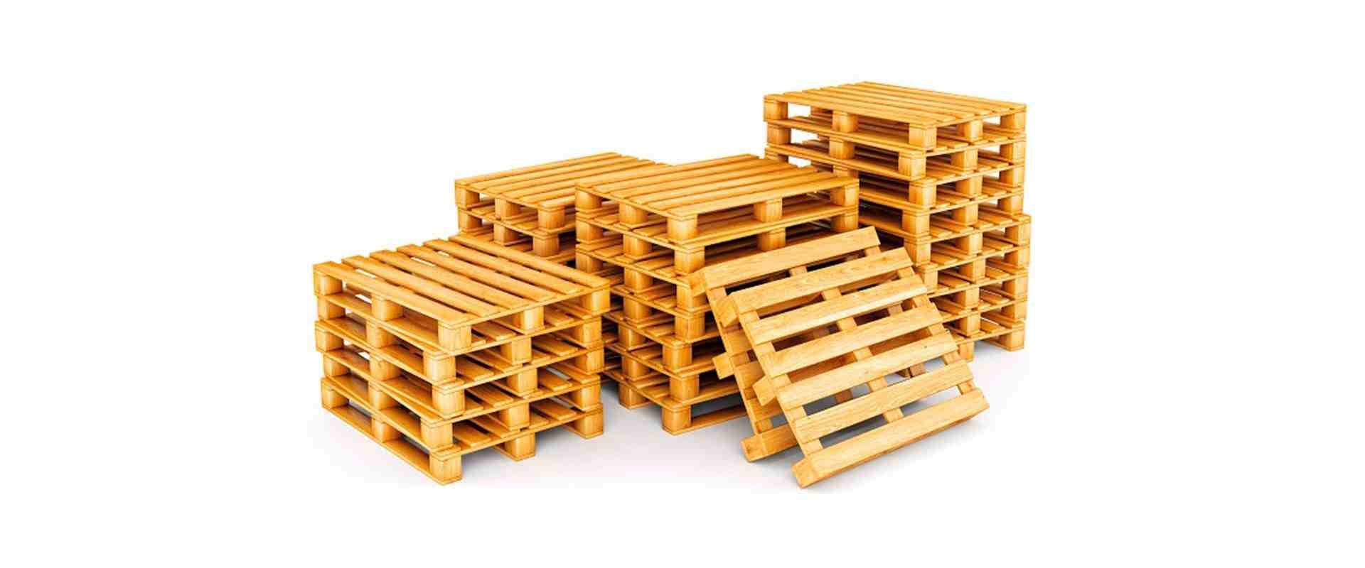 Una pila de palés de madera de color claro, uno de ellos apoyado contra la parte delantera del montón.
