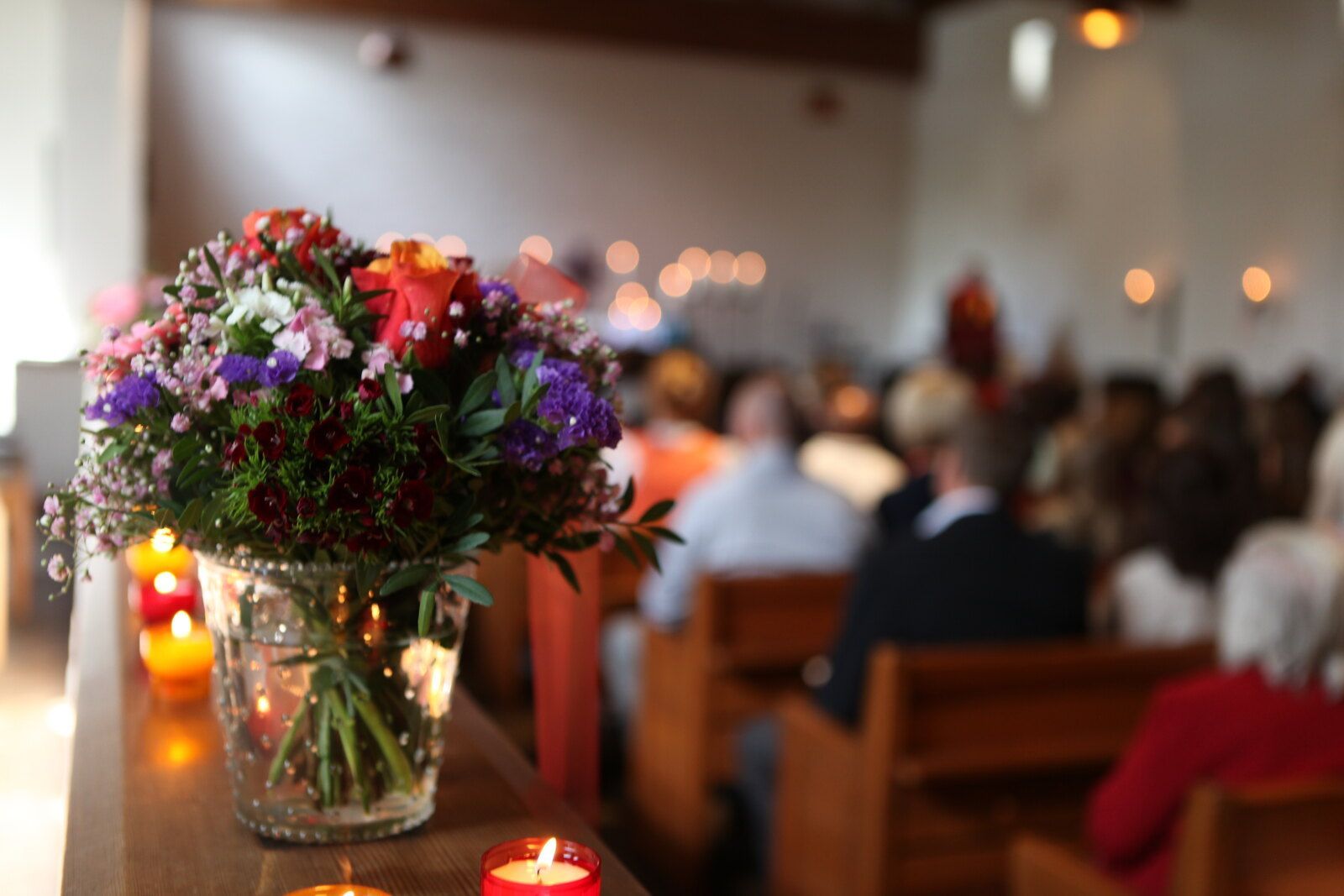 Eine Vase mit Blumen steht auf einem Tisch in einer Kirche