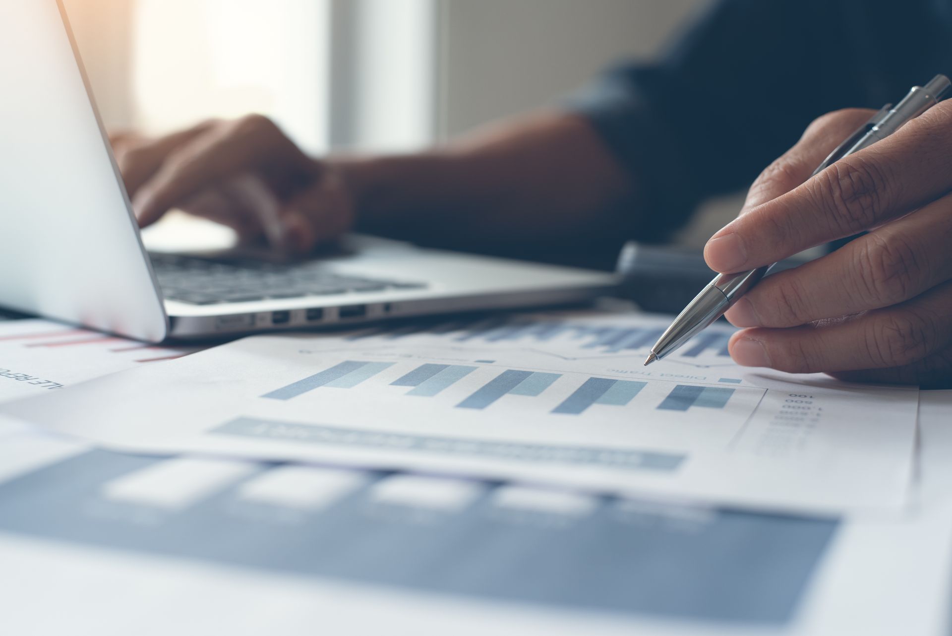 Personne avec un ordinateur et documents avec graphiques