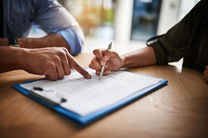 Une personne qui pointe du doigt une information sur un document