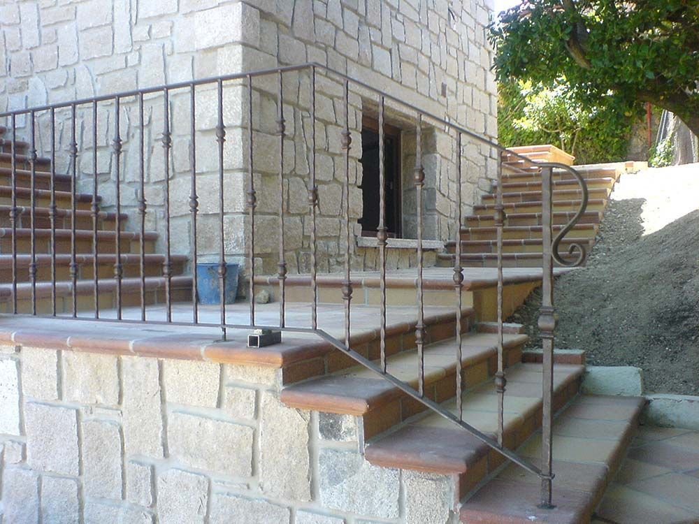 Exterior de edificio de piedra con barandilla de metal a lo largo de las escaleras exteriores.