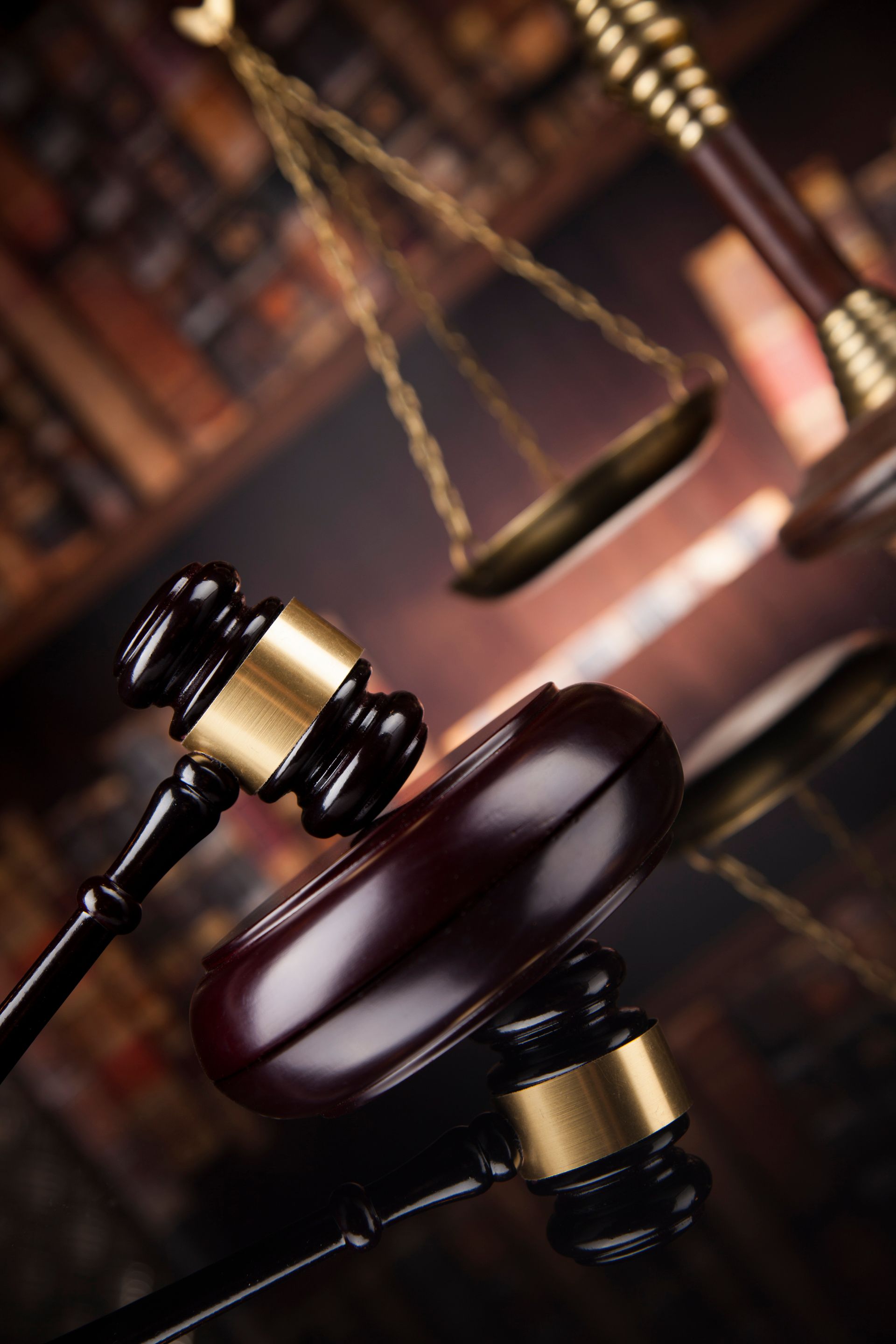 Un marteau de juge posé sur une table à côté d'une balance de justice
