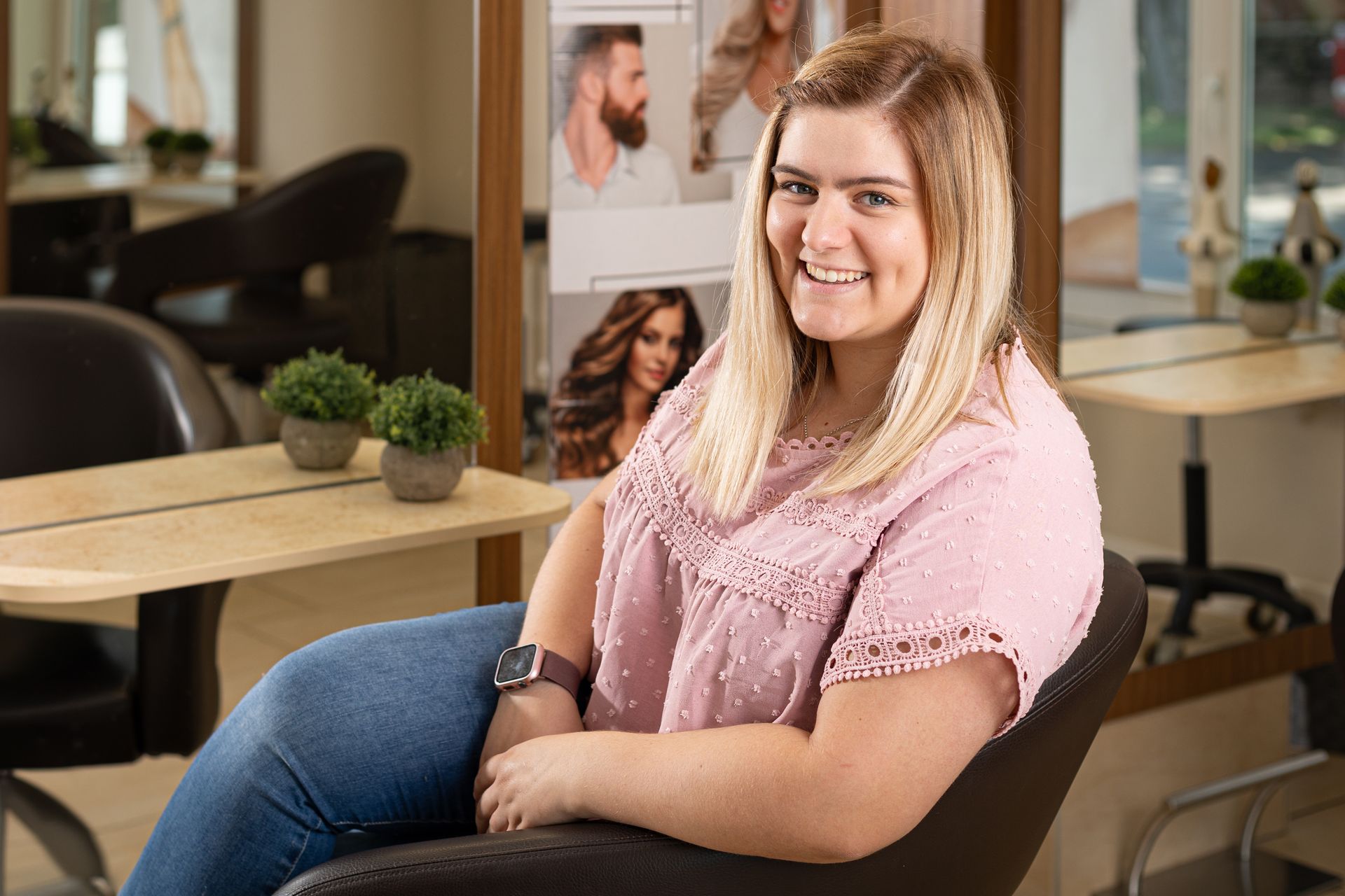 Eine Frau sitzt in einem Friseursalon auf einem Stuhl.