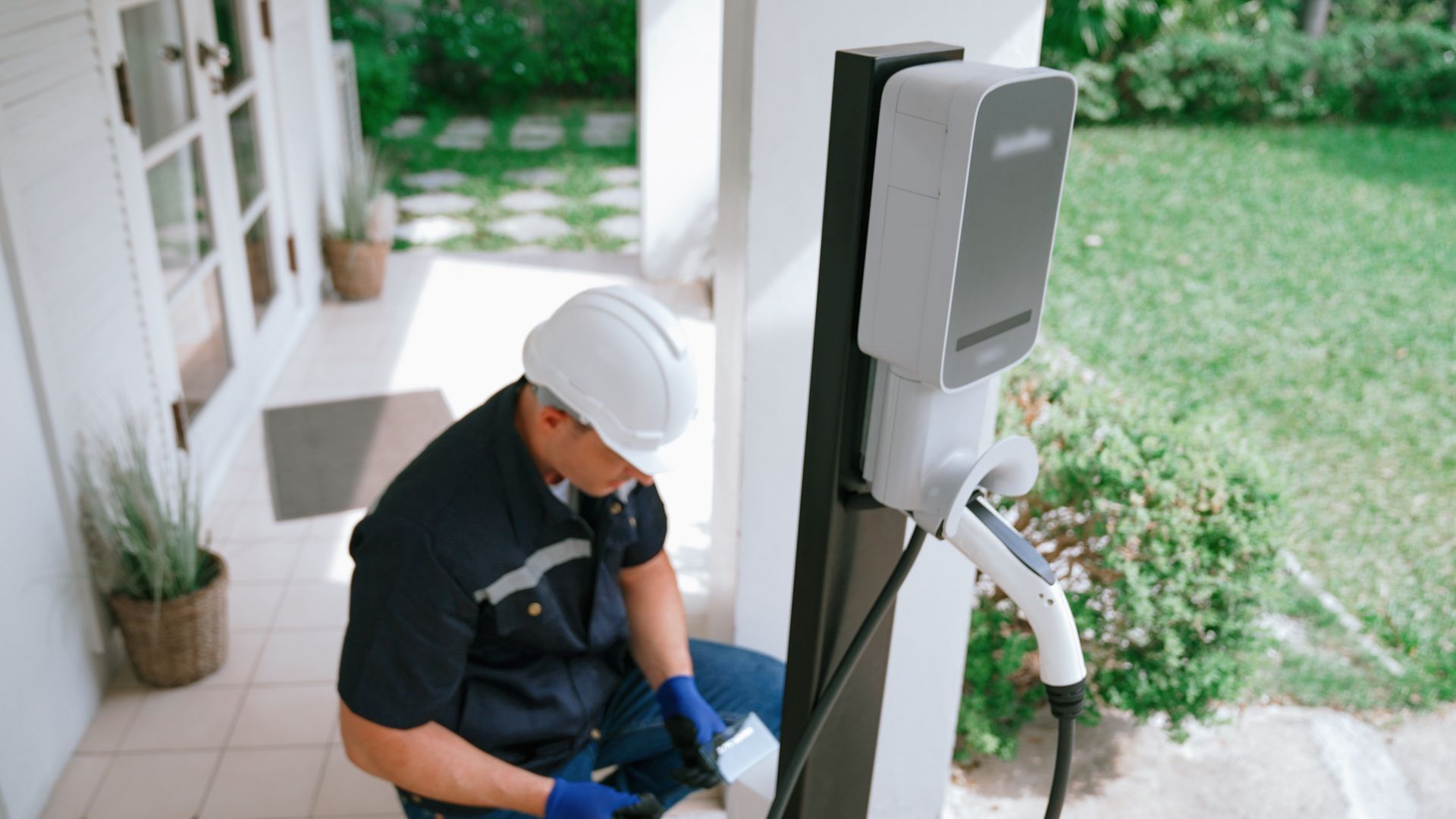Un homme installe une borne de recharge