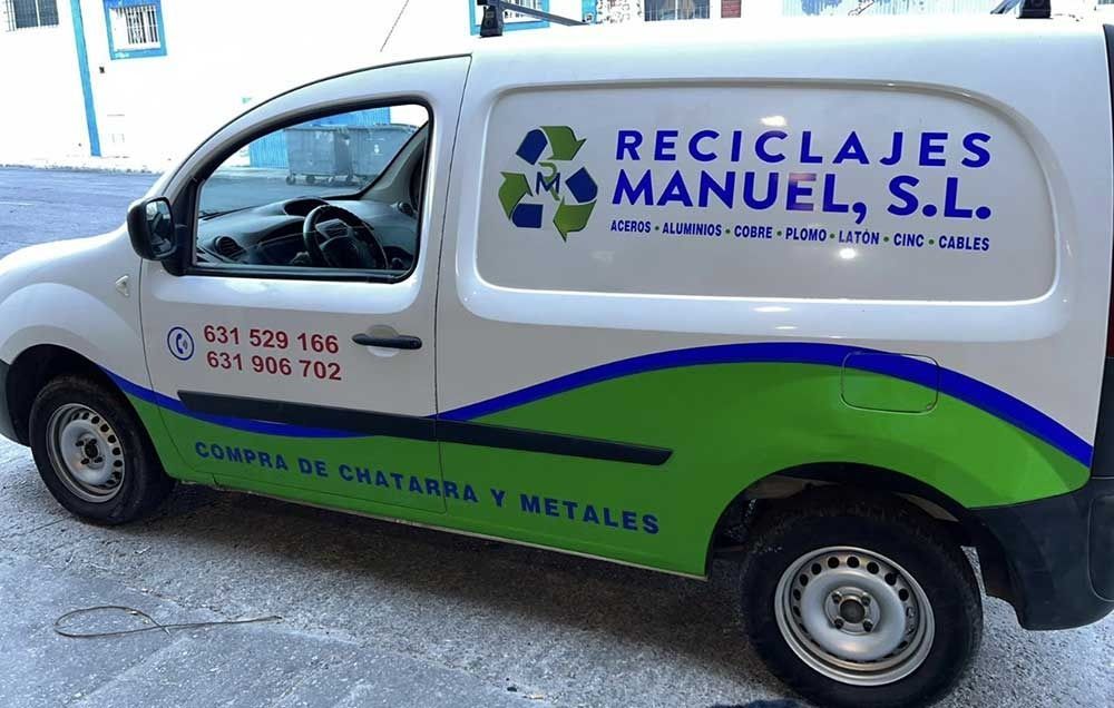 Furgoneta de reciclaje blanca y verde con el letrero “Reciclajes Manuel, SL” estacionada al aire libre.