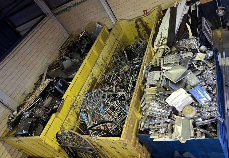 Contenedores desbordados de chatarra de metales mixtos en un depósito de reciclaje industrial.