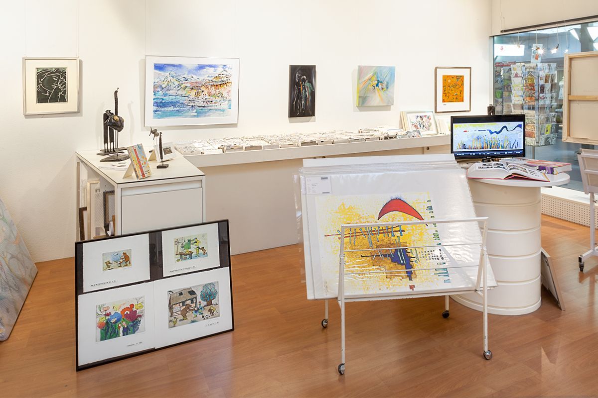 Ein zweistöckiges Haus im Bau, mit Leitern und Gerüsten, vor blauem Himmel. Beige-weisse Fassade, umgeben von anderen Häusern.