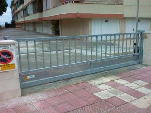 Una puerta corrediza se abre a un estacionamiento al lado de un edificio.
