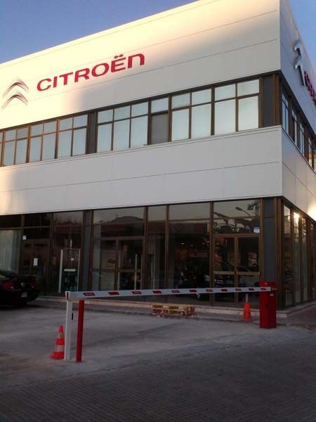 Un edificio Citroën con una barrera roja delante.