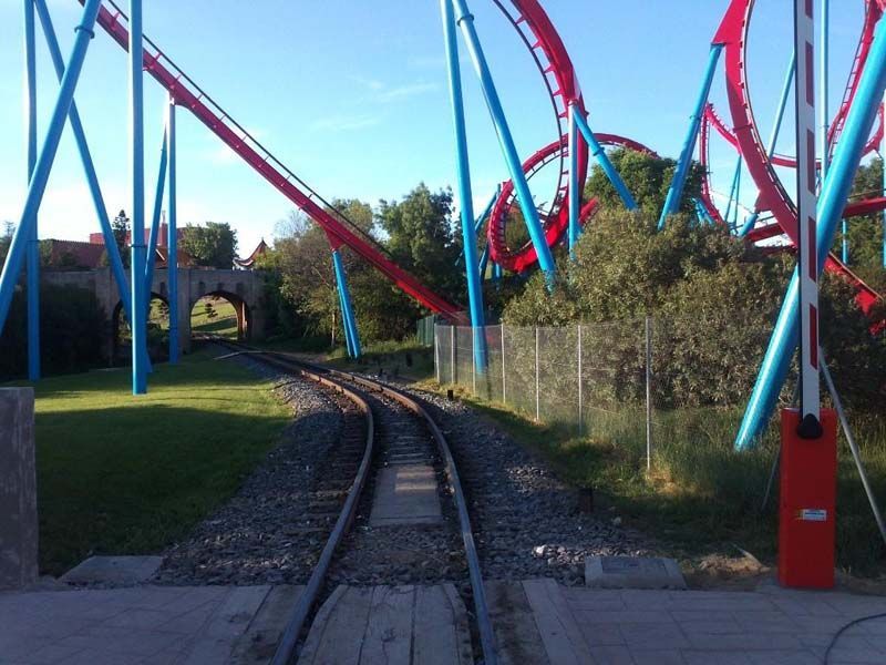 Una montaña rusa va por unas vías de tren.