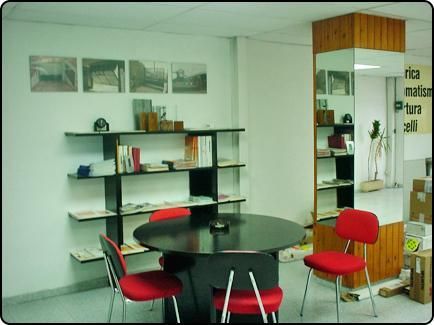 Una habitación con una mesa redonda y sillas rojas.