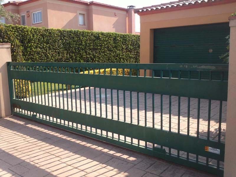 Una puerta corrediza verde delante de una casa