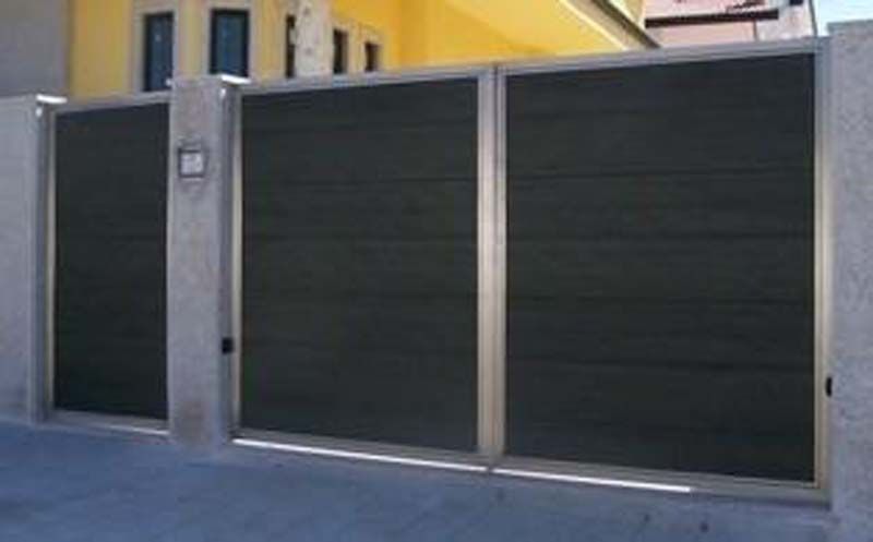 Una puerta corrediza con marco de acero inoxidable está delante de una casa.