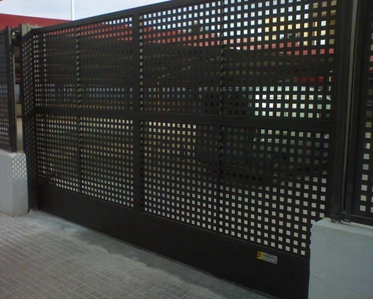 Una valla de metal negra con agujeros.