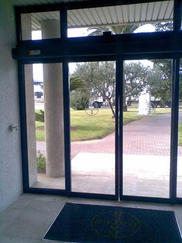 Una puerta corrediza de vidrio con un tapete delante.