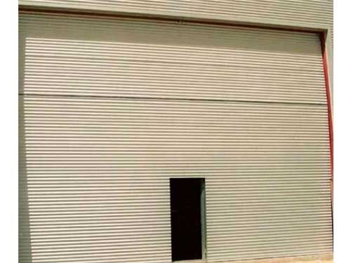 Una gran puerta de garaje blanca con una pequeña puerta en el medio.