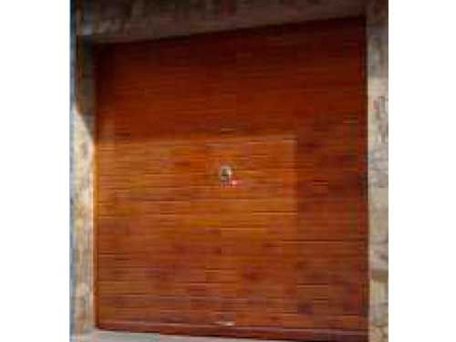 Un primer plano de una puerta de garaje de madera con un timbre.