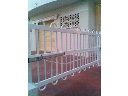 Una puerta de metal blanco está frente a un edificio blanco.