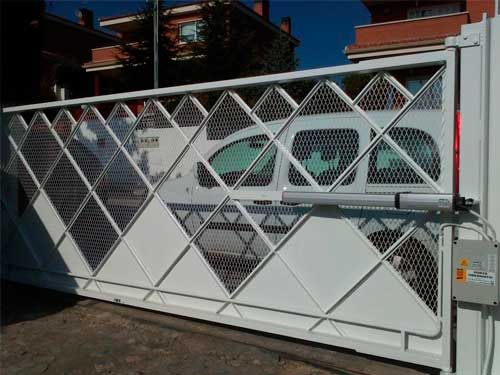 Una puerta corrediza blanca con un coche aparcado detrás.