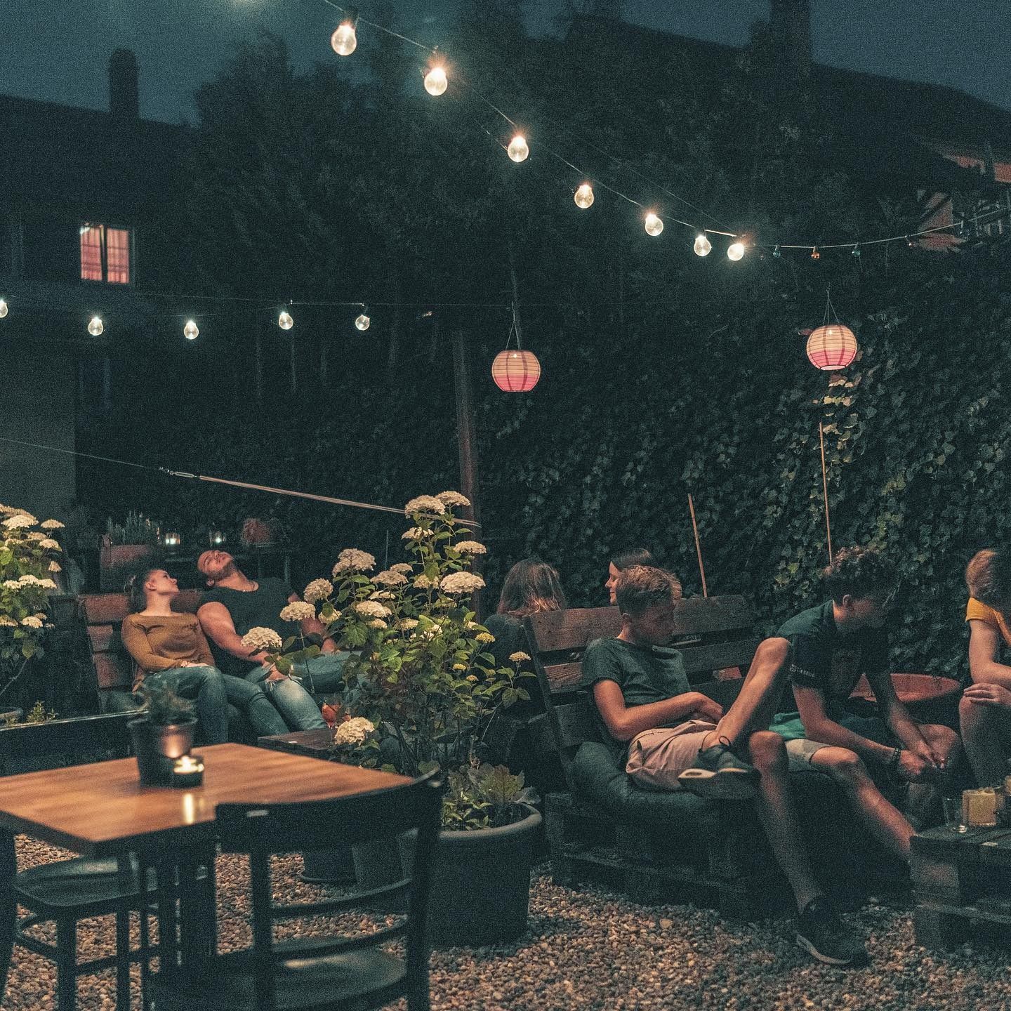 Ein Teller mit Essen auf einem Holztisch, im Hintergrund verschwommene Restaurantgäste.