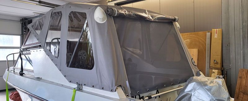 In einer Garage steht ein Boot mit einem Verdeck.