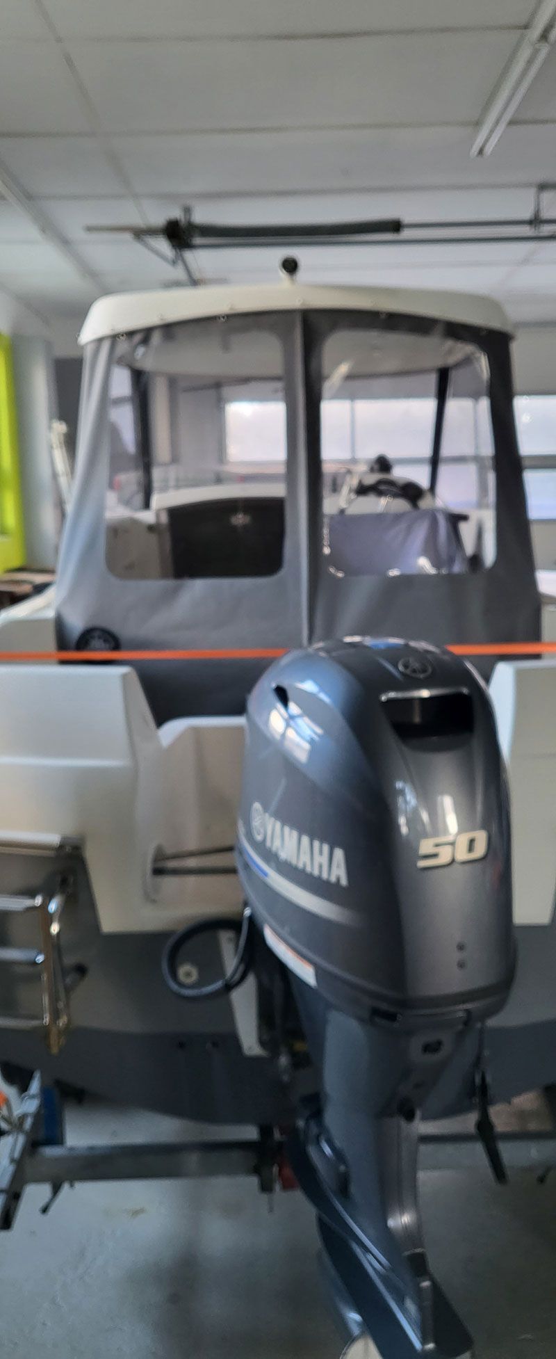 In einer Garage steht ein Boot mit einem Yamaha-Außenbordmotor.