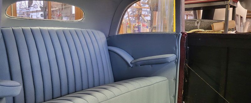 Auf dem Rücksitz eines Autos steht ein blaues Sofa.