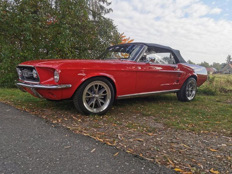 Ein rotes Mustang-Cabriolet steht am Straßenrand.