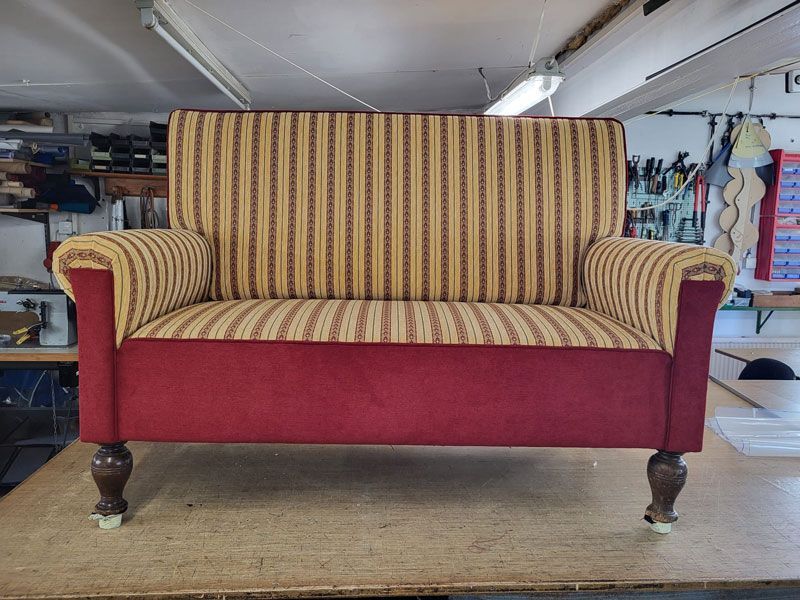 Auf einem Tisch steht ein rot-gelb gestreiftes Sofa