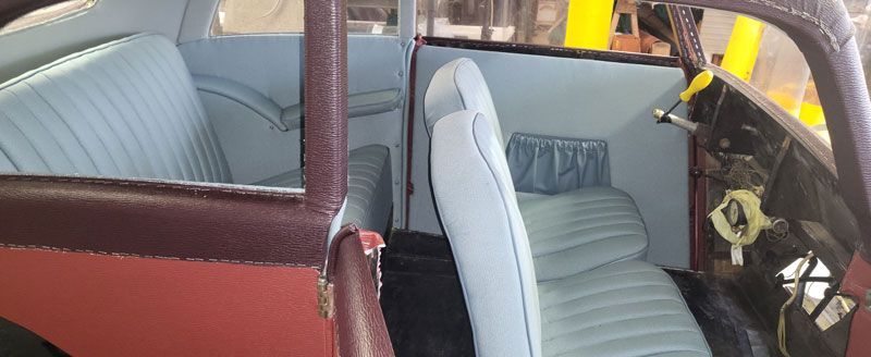 Eine Nahaufnahme des Innenraums eines Autos mit blauen Sitzen.