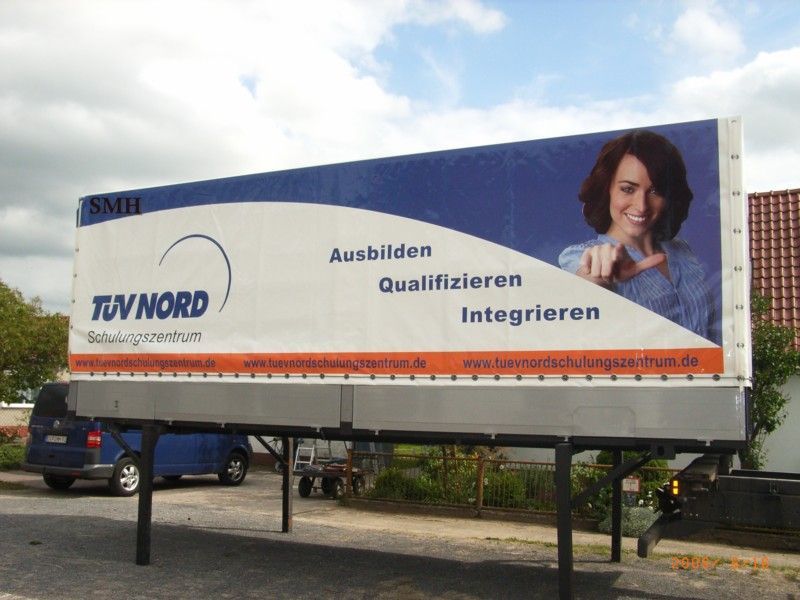 Eine große blau-weiße Plakatwand für TÜV Nord
