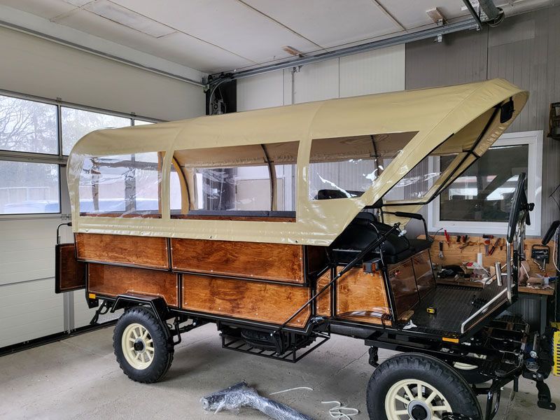 In einer Garage steht ein Holzwagen mit Überdachung.