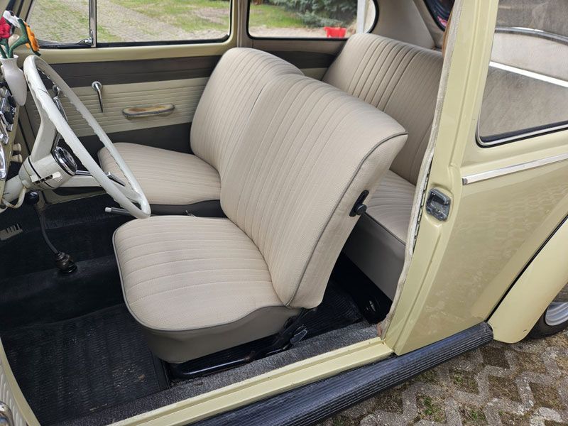 Der Innenraum eines gelben Autos mit weißen Sitzen und einem Lenkrad.