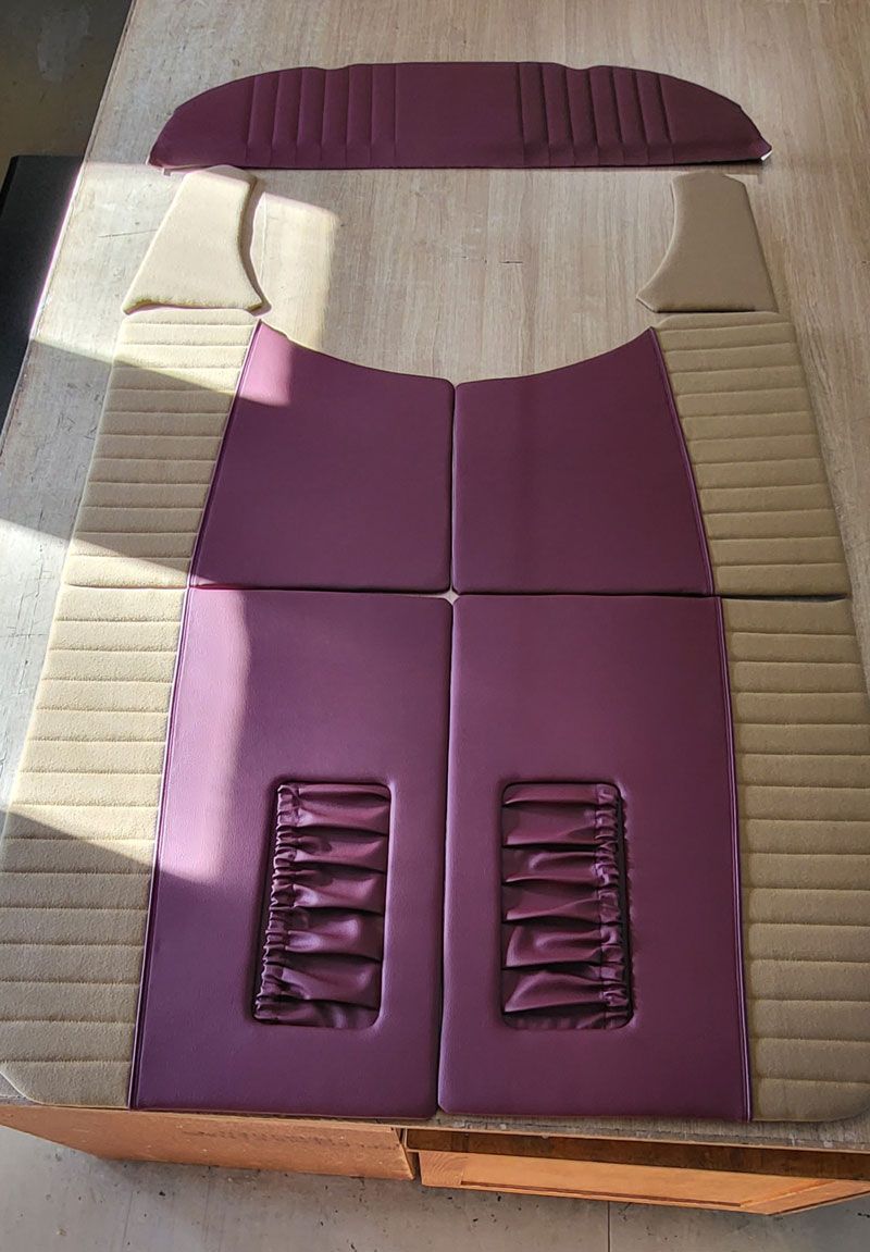 Auf einem Holztisch liegt ein lila-braunes Kissen.